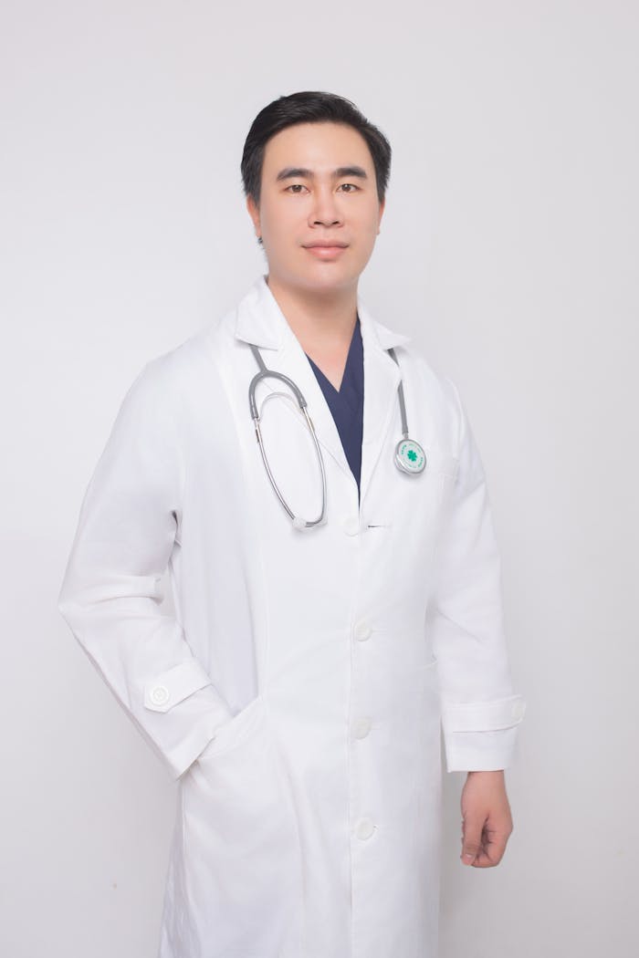 Professional doctor in a white coat with a stethoscope in a studio setting.