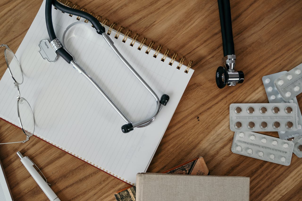 Flat lay of medical tools and supplies on a wooden desk surface.