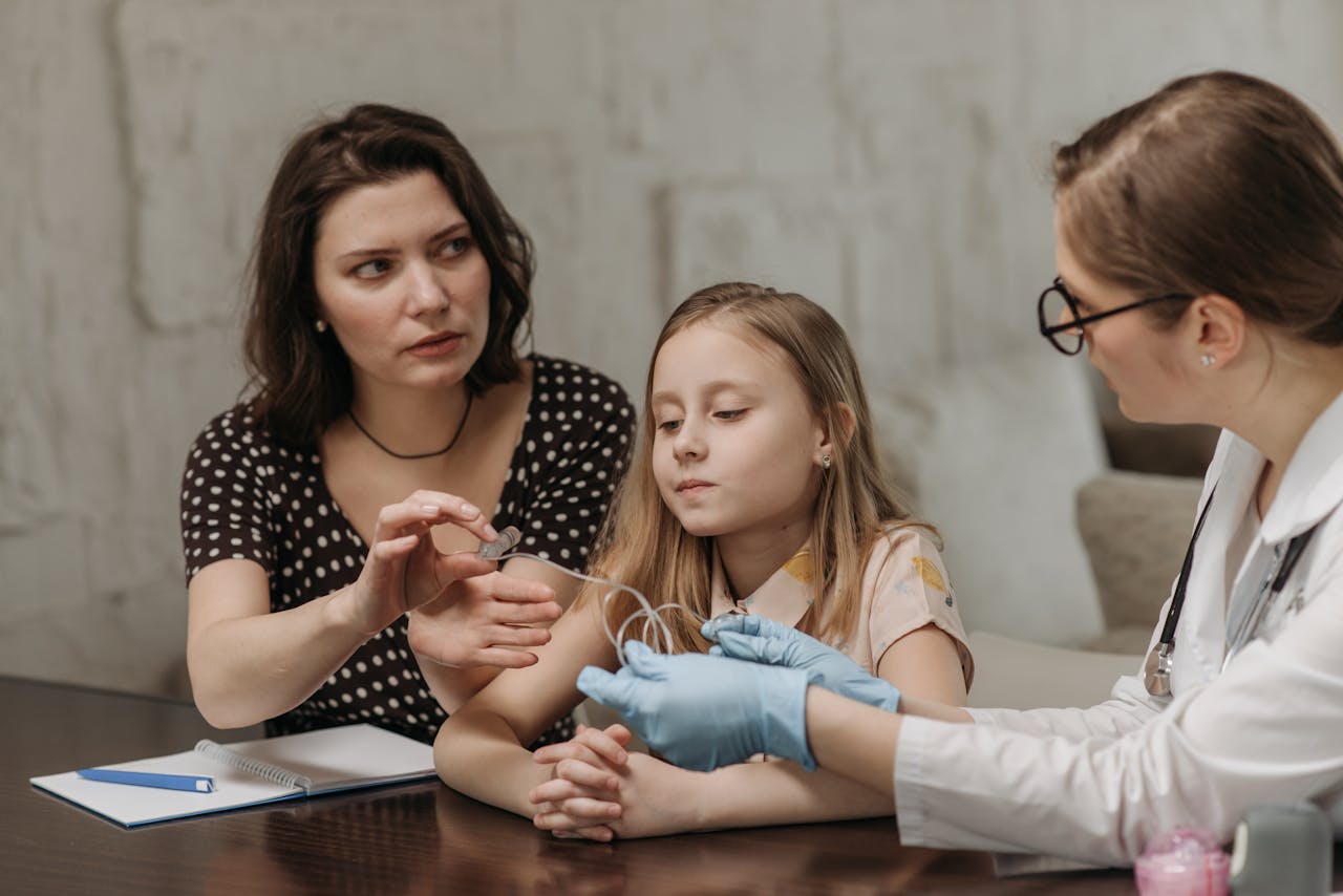 A mother and daughter consult a doctor during a home visit for healthcare advice.